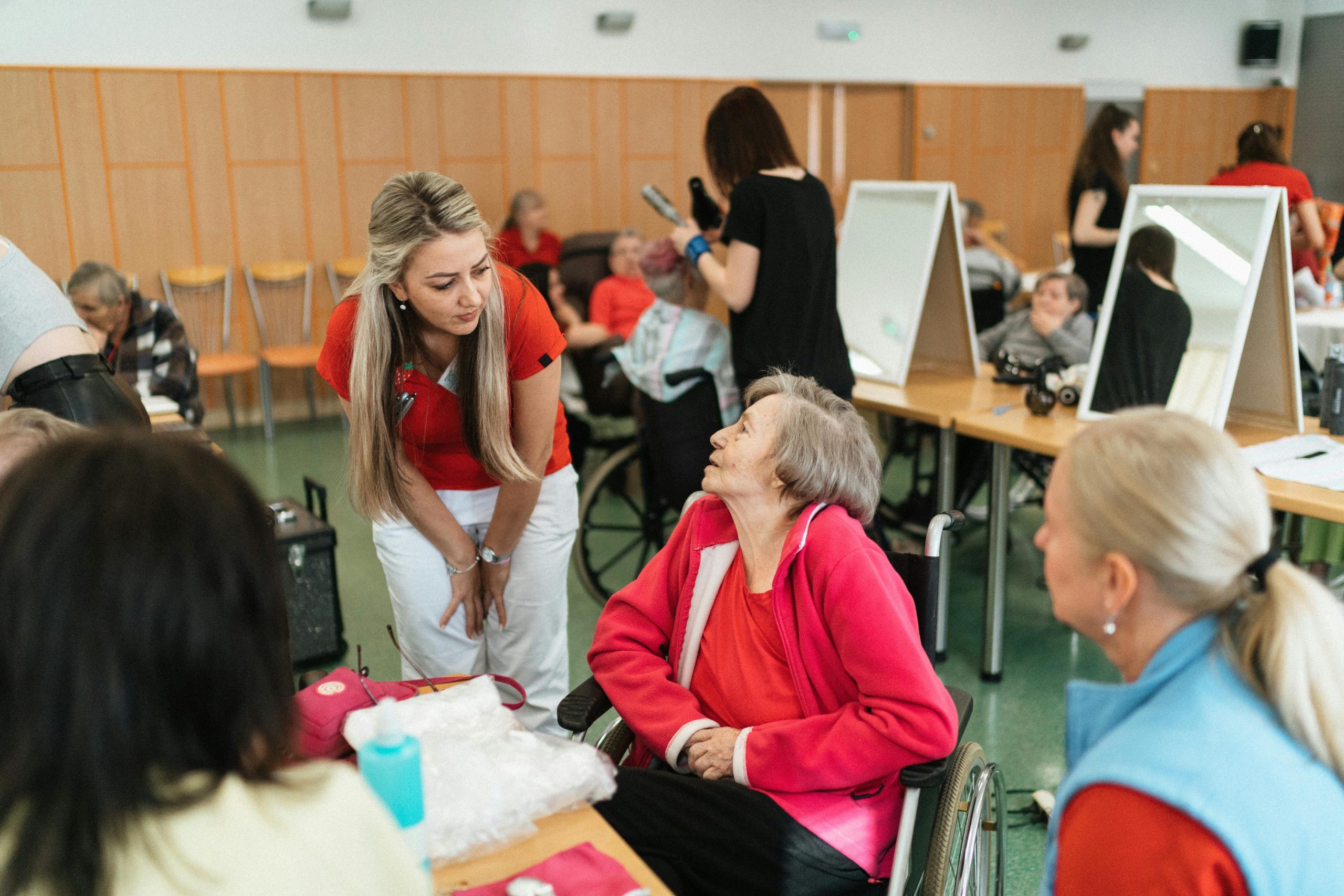 vårdpersonal i samtal med patient i en aktivitetslokal för äldre